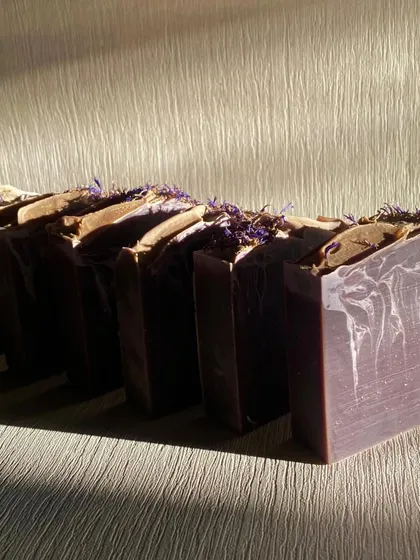 Our Purple Rain soap loaf, topped with dried botanicals before cutting. The calming aroma is a blend of Lavender, Geranium, and a touch of Vanilla and Lemon essential oils.