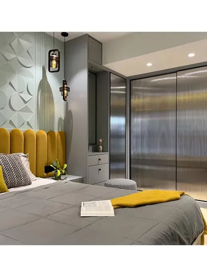 The fluted glass wardrobe doors add a touch of modern sophistication and texture, beautifully complementing the 3D wall panels and the plush velvet headboard.