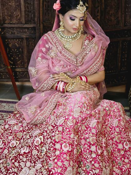 A full view of the pink and red velvet lehenga, showing the beautiful drape and heavy embroidery. A true statement piece for any bride.