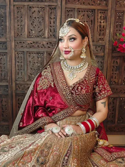 This look showcases a beautiful velvet maroon lehenga paired with a heavy Polki and pearl bridal set. The entire outfit, from the lehenga to the jewellery, is available for rent.