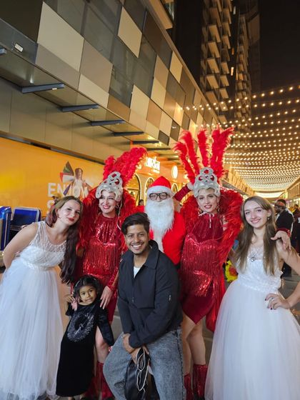 Our team of entertainers, including Santa and costumed dancers, posing with guests at a Christmas celebration. We love interacting with the crowd and making everyone feel part of the magic.