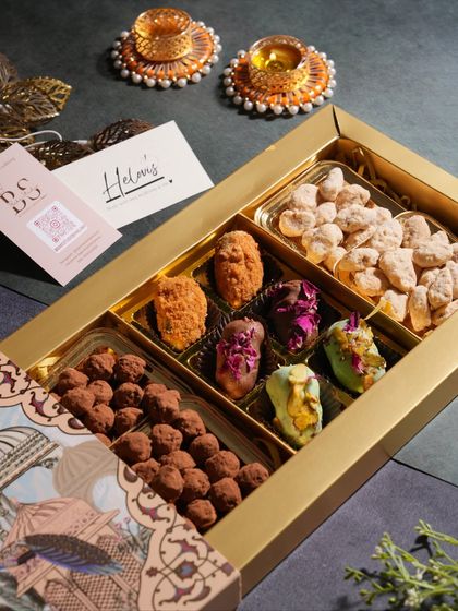 An elegant Diwali gift hamper filled with a variety of my handcrafted treats. This box includes chocolate truffles, assorted center-filled dates, and chai masala almonds.