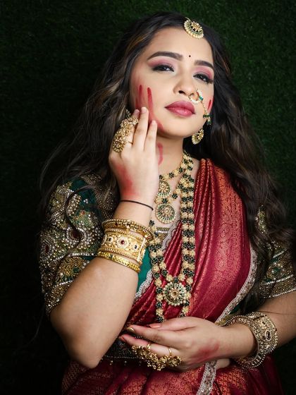 The heavy gold-finish jewellery stands out beautifully against the rich colors of the outfit.