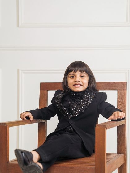 For a truly unique party look, I designed this tuxedo with a full sequin cowl neck detail. Here, the model is seated, showing how the outfit remains comfortable and stylish.