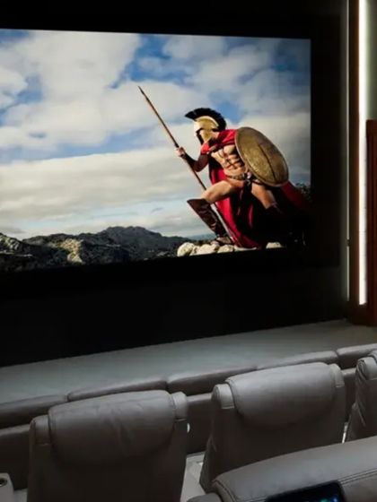 We bring globally renowned brands like Sony and JVC to your home. This setup, with its large projection screen and comfortable cinema-style seating, is expertly calibrated by our team to ensure the best possible audio and video experience.