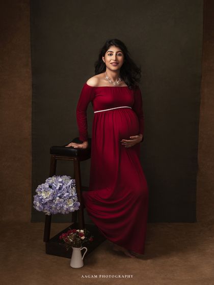 This off-the-shoulder red gown is a classic choice, shown here in a full-length portrait with floral accents.
