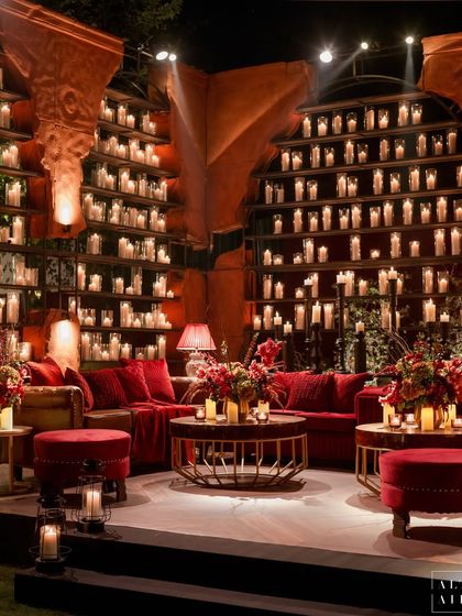 A cozy lounge area from 'Laal Bagh', featuring a massive wall of candles set into arched niches. This design element provided a stunning backdrop and filled the space with a soft, romantic light, creating an intimate and luxurious vibe.