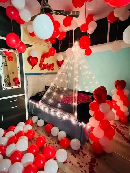 I transform entire rooms for a truly romantic experience. This decoration includes hundreds of red and white balloons on the floor and ceiling, a beautiful light-up canopy over the bed, and balloon pillars for a complete romantic immersion.
