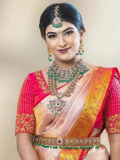 A full view of the kemp jewellery set, including the vaddanam, which perfectly complements the pink silk saree.