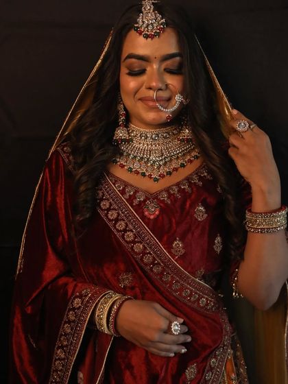 A lovely shot of the bride in a rich maroon velvet lehenga, showing the intricate jewellery and soft makeup.