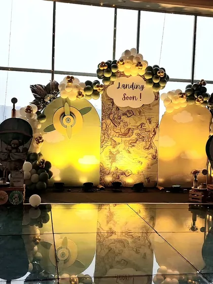 A creative and charming "Landing Soon" baby shower backdrop. This travel-themed design features a world map, airplane propellers, and fluffy clouds, perfect for celebrating the new adventure of parenthood for a pilot couple.