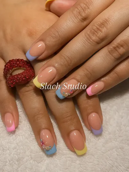 Another view of the popular pastel French tips, showing how the colors work together. The accent nails feature tiny floral details for an extra touch of personality.