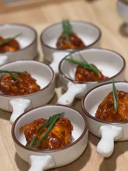 Can you guess this starter? It's our spicy Korean-style cottage cheese bites, glazed in a gochujang sauce and topped with spring onions.