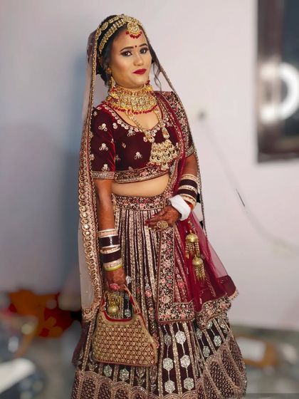 This bride is dressed in a deep maroon velvet lehenga. I created a matching makeup look with a bold lip and soft, glowing skin.