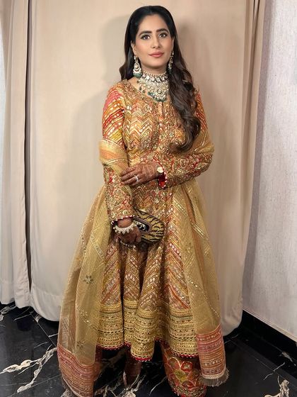 A full-length view of the client, her traditional outfit and glamorous makeup creating a stunning combination.