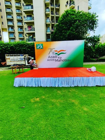 The main stage setup for an Independence Day event, featuring a large backdrop for 'Azadi Ka Amrit Mahotsav'. The stage is covered with a red carpet and has a clean white skirt.
