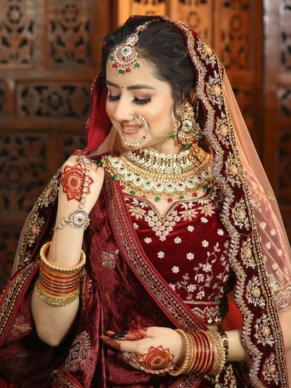 A shy, happy moment captured. This bride's makeup in her velvet maroon lehenga is soft yet defined, with beautiful henna detailing.