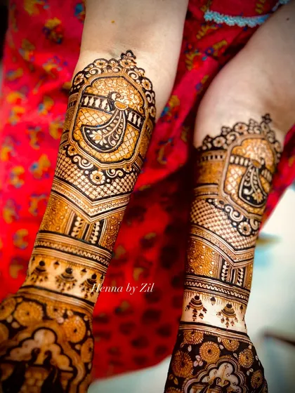 A beautiful bridal design with peacock motifs framed in ornate jharokha-style windows on the arms.