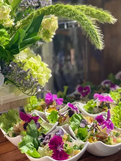 Fresh and vibrant salad cups adorned with edible flowers. Each cup is a mini garden of crisp lettuce, fresh vegetables, and a light vinaigrette, perfect for a healthy and beautiful starter.
