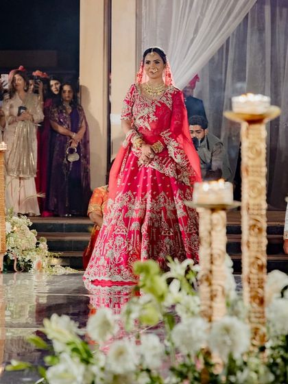The bride's grand entrance, walking along the mirrored aisle lined with candles and white flowers. The entire setting was designed to make her feel like royalty on her special day.