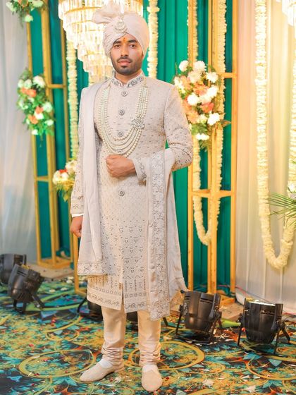 A confident pose showing the groom's full wedding day attire.