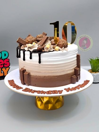 A tempting chocolate overload cake with an ombre effect, topped with a variety of chocolates like KitKat and Ferrero Rocher.