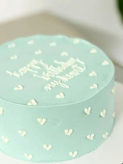 A minimalist and modern romantic cake. This light blue cake with tiny white hearts and the message "happy birthday my heart" is sweet and personal.