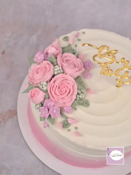 A close-up of the piped buttercream roses on the bridal shower cake.