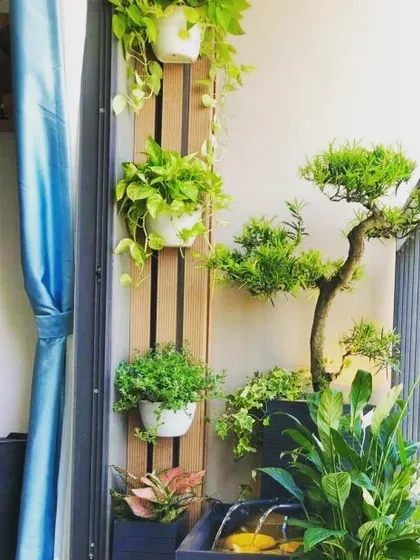 Even a tiny corner can have a water feature. This small, self-contained fountain adds the gentle sound of water to a balcony garden, enhancing the feeling of being in a natural, peaceful space.