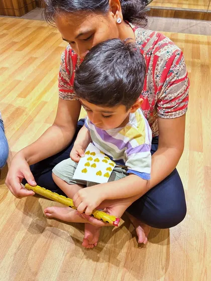 A parent and child work together on a craft activity during our workshop. Our sessions incorporate multiple art forms to create a holistic learning experience.