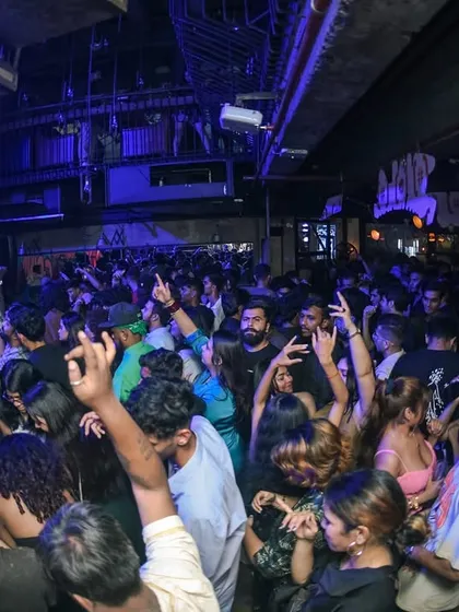 Another angle of the packed club, hands in the air.