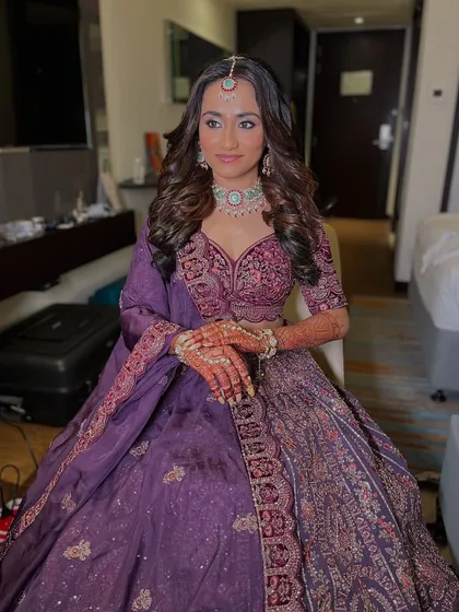 This bride chose a gorgeous purple lehenga for one of her wedding events. The delicate zircon necklace with light blue stones adds a subtle touch of color and modern elegance to her look.