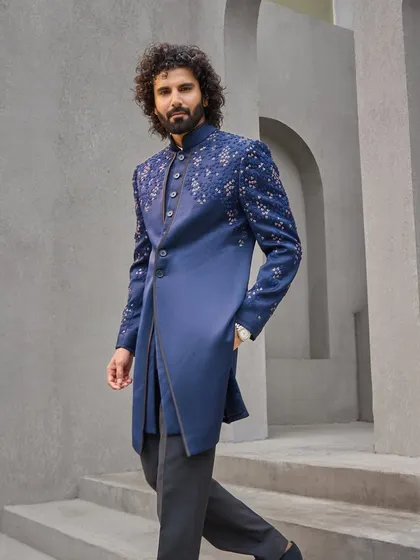 This is my modern take on the classic bandhgala. Crafted in a deep indigo, the asymmetrical cut and scattered embroidery on the shoulder and sleeve offer a contemporary edge, making it a perfect outfit for a Sangeet or reception.