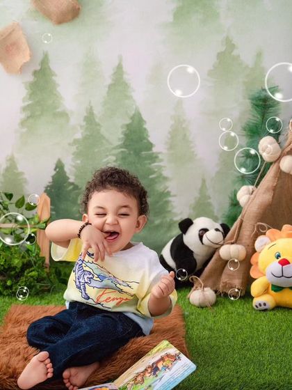 Roaring with laughter, this little one is having a wild time in our jungle paradise, surrounded by his favorite animal toys.
