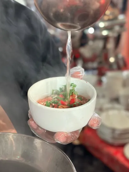 The steam rising from a freshly poured bowl of Thai broth signifies the heat and freshness of the dish. It's a sensory experience that begins even before the first bite.