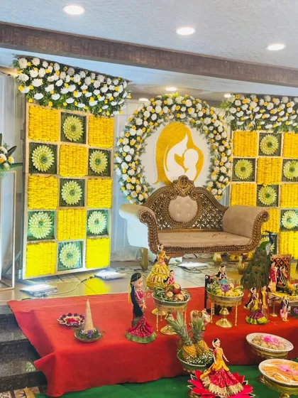 For a traditional Seemantha or baby shower, we use beautiful floral arrangements to create a blessed and elegant atmosphere. This stage features a stunning backdrop of yellow and white flowers, with a classic sofa for the mother-to-be.