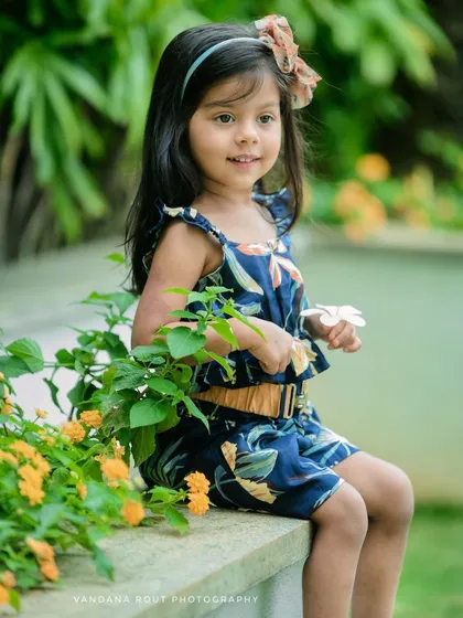 Outdoor sessions allow for beautiful, natural portraits like this one. I use the soft light and lush greenery of a garden setting to create a dreamy, candid shot that highlights a child's natural curiosity and innocence.