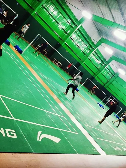 The energy on a Sunday morning is unmatched. This dynamic shot captures players fully engaged in a game on our vibrant green synthetic courts.