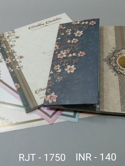 This vertical invitation set features a variety of floral patterns, from a dark blue cover to lighter pastel inserts. It's a versatile design for a stylish wedding.