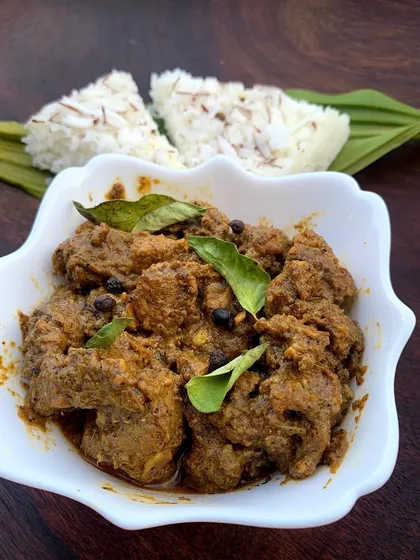 Our classic Pandi Curry served with sannas, the soft, fluffy steamed rice cakes that are perfect for soaking up every last bit of the flavorful gravy.