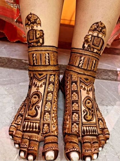 This foot mehendi features a classic design with elephants under a canopy and detailed patterns covering the entire foot, perfect for a traditional bride.