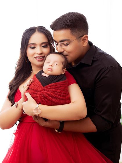 A close-up of the new family, filled with love and affection. The focus is on their happy expressions and their precious newborn.