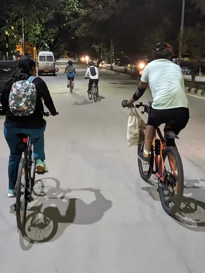 A shot from behind, following the group as we ride down a well-lit road. There's a unique sense of camaraderie and safety when we ride together like this.