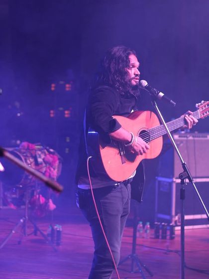 Nikhil Paul George performing with his guitar during the special collaborative concert.