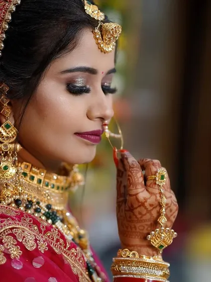 A detailed bridal portrait capturing the bride's serene expression and intricate details. We focus on beautiful close-ups that highlight the makeup, jewelry, and delicate henna, preserving the elegance of the moment.