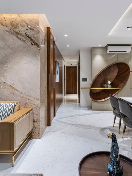 An alternate view of the Filigree House, showing the unique, curved wooden shelving unit in the dining area. This bespoke piece acts as both storage and sculpture, adding an artistic touch to the space.