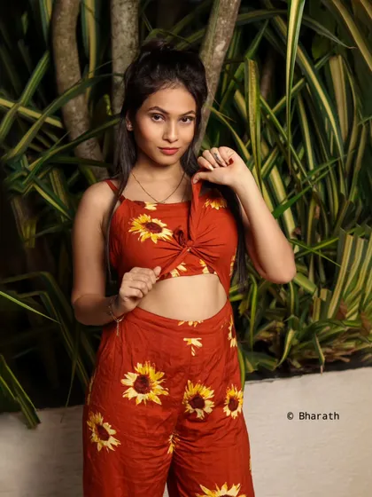 A close-up of the same outfit, focusing on the tie-front detail of the top and the model's playful expression.