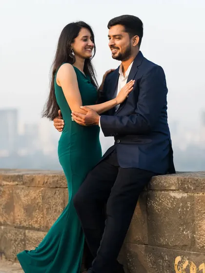 A romantic pre-wedding shot with the city skyline in the background, capturing an intimate moment between the couple.
