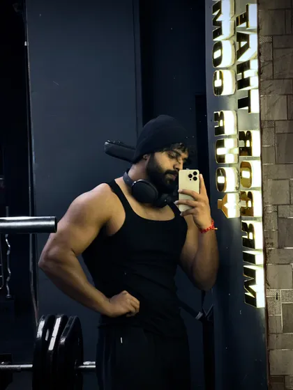 A trainer takes a moment after a workout. This selfie captures the gym's modern aesthetic, with our lit-up motivational signs and professional-grade equipment in the background.