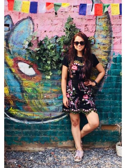 Standing out against a colorful background in an equally colorful dress. This black dress with vibrant floral embroidery is a fun, eye-catching piece that's perfect for making a statement.